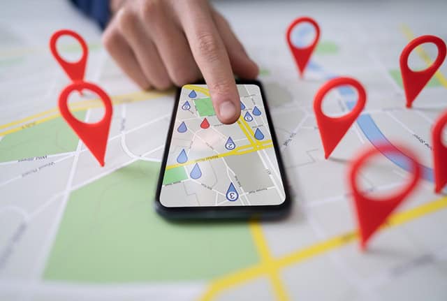 ATK Local Search Engine Optimisation Consultancy Thumbnail. Finger pointing at a mobile phone with Google maps on the screen.